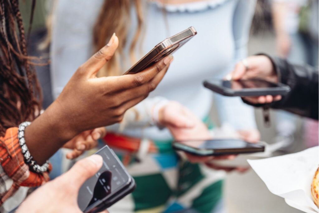 Menschen stehen im Kreis und haben alle ihr Handy in der Hand